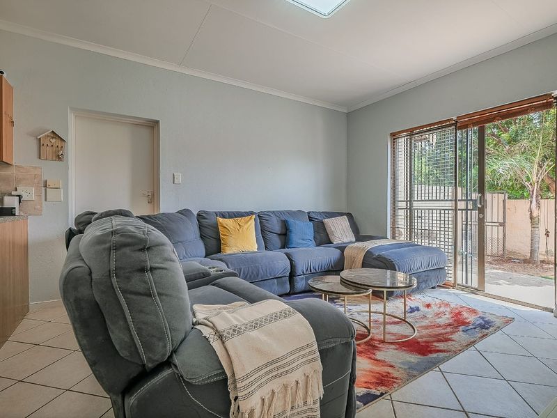 Open plan living area featuring tiled flooring, a skylight, and a sliding glass door providing direct access to the outdoor space.