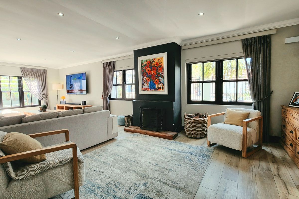A well-maintained living room featuring a central fireplace, recessed lighting, and modern laminate flooring, creating a comfortable and inviting atmosphere.
