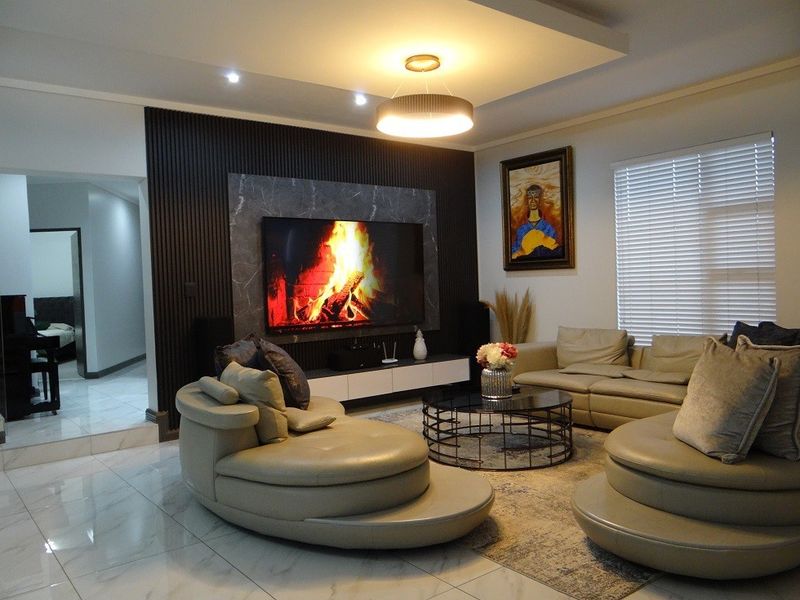 Modern living room featuring a striking slatted wood and marble feature wall, recessed ceiling lighting, and polished tiled flooring.