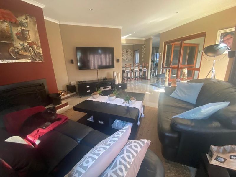 Spacious open-plan living area featuring a built-in fireplace, tiled flooring, and seamless flow to the dining space and outdoor access.