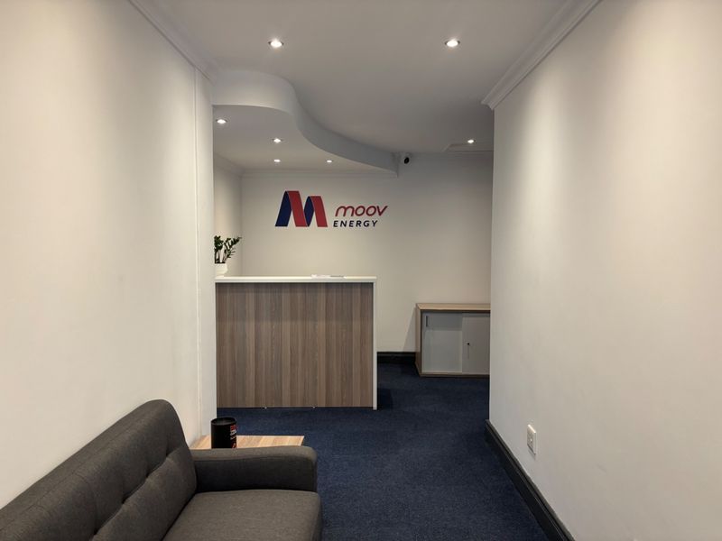 A professional office reception area featuring a built-in desk, recessed lighting, and clean finishes, creating a welcoming entrance for clients.