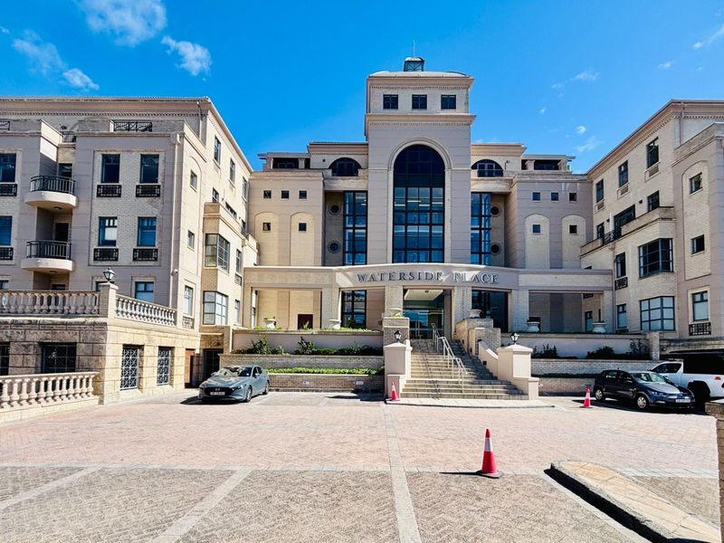 Front elevation of Waterside Place, a multi-story office building featuring a paved driveway, stone balustrades, and a prominent central entrance.