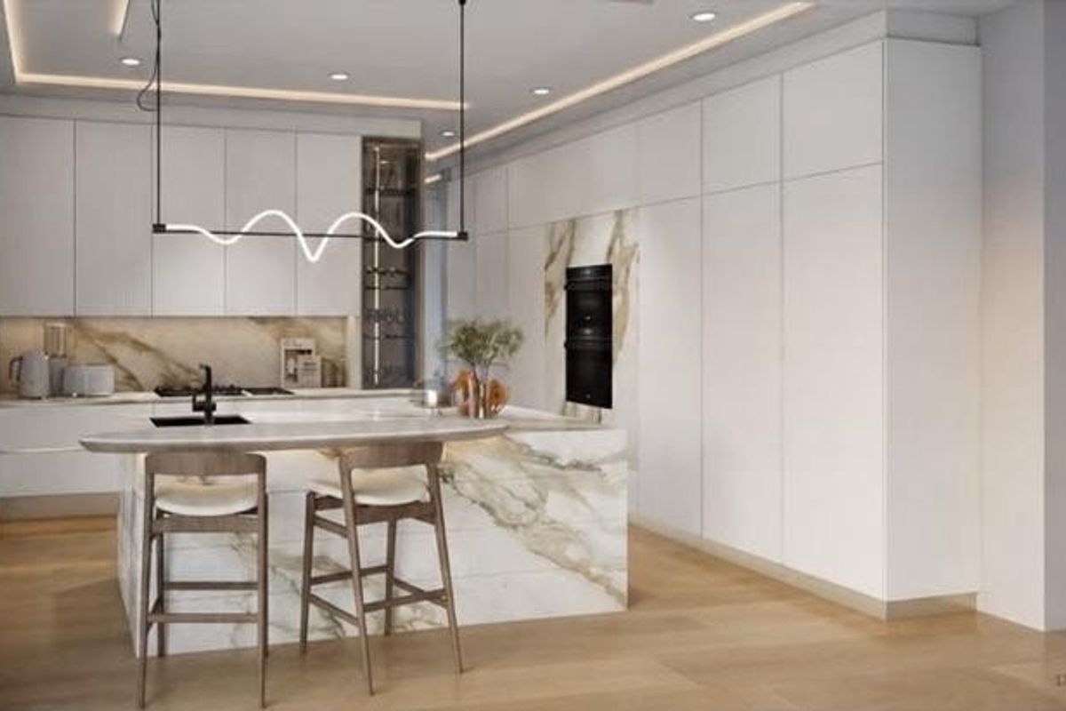 Modern luxury kitchen featuring sleek white cabinetry, a striking marble island with integrated seating, premium built-in appliances, and sophisticated recessed and cove lighting.