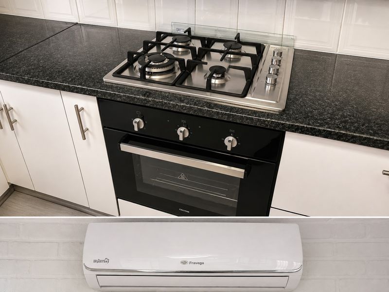 Modern kitchen featuring a built-in oven, gas cooktop with granite countertops, tiled backsplash, and a wall-mounted inverter air conditioning unit.