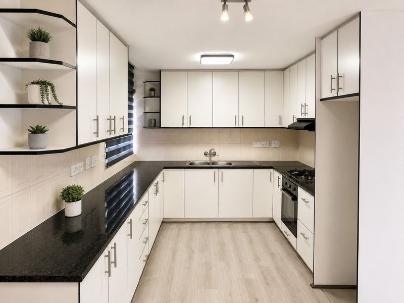 Modern U-shaped kitchen featuring white cabinetry, black granite countertops, integrated oven, gas hob, and high-quality laminate flooring.
