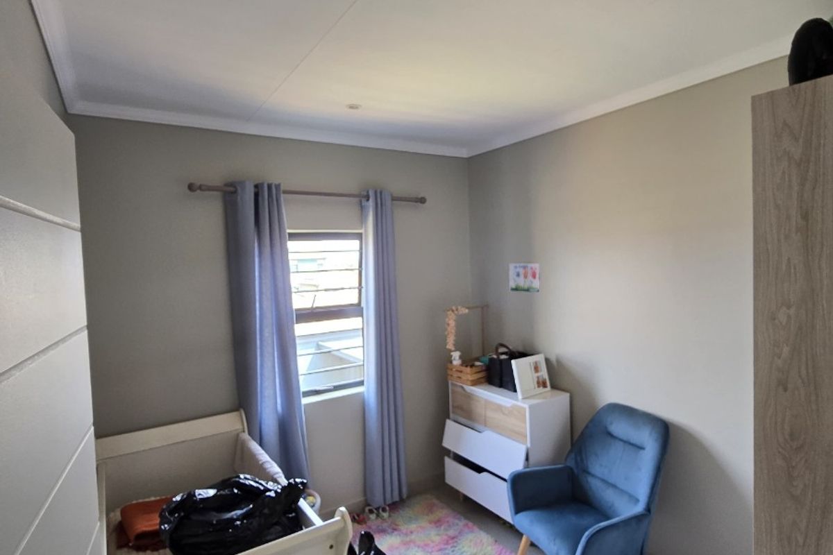 A well-maintained bedroom featuring neutral wall tones, tiled flooring, recessed ceiling lighting, and a built-in cupboard.