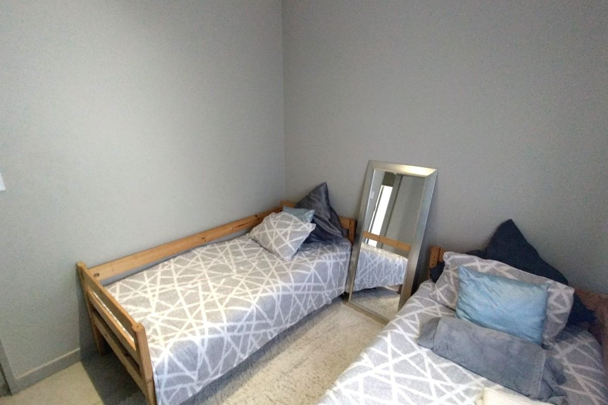 A simple bedroom featuring neutral wall paint and tiled flooring, suitable for a guest room or children's bedroom.
