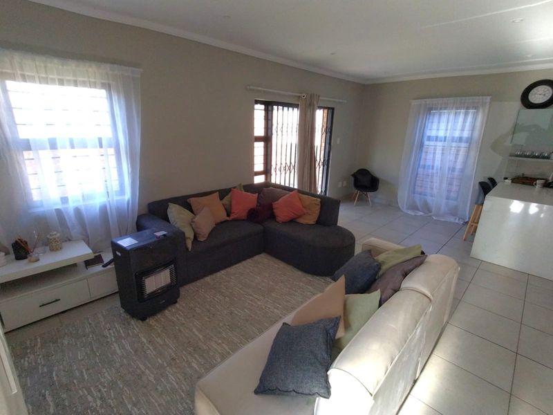 Spacious open-plan living area featuring tiled flooring, recessed lighting, and a kitchen island, providing a versatile layout for dining and relaxation.