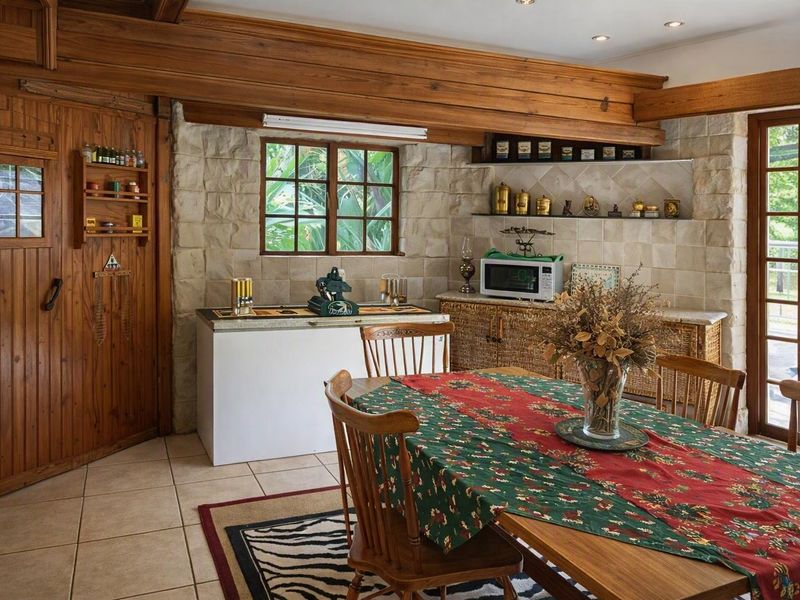 A rustic dining area featuring exposed timber ceiling beams, stone-clad walls, and tiled flooring, creating a warm and traditional atmosphere.