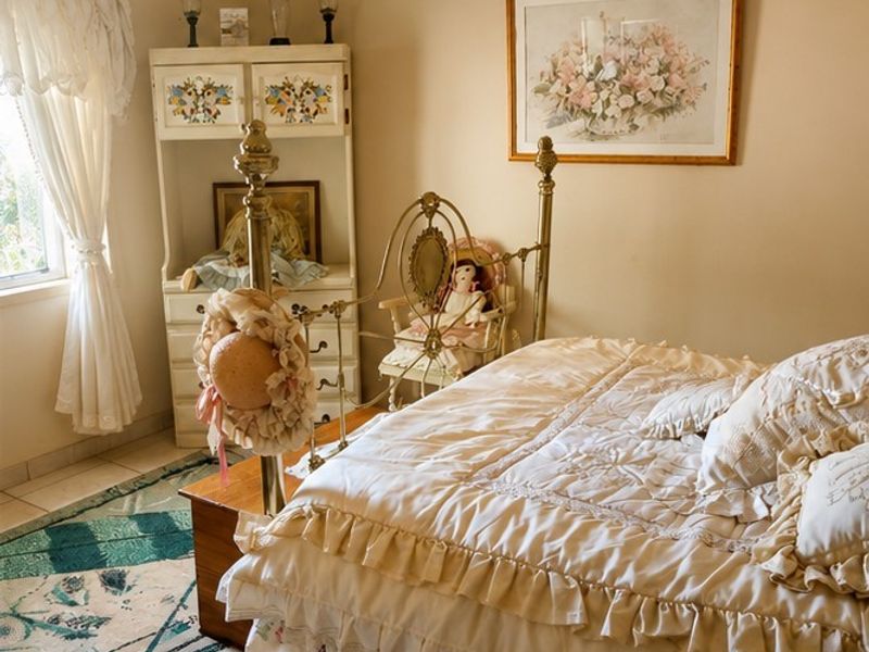 A cozy bedroom featuring tiled flooring and neutral wall tones, offering a comfortable and traditional living space.