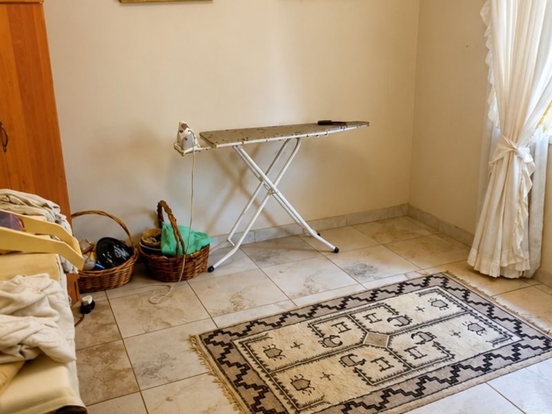 A functional laundry area featuring neutral wall tones and durable tiled flooring, providing a practical space for household utility tasks.