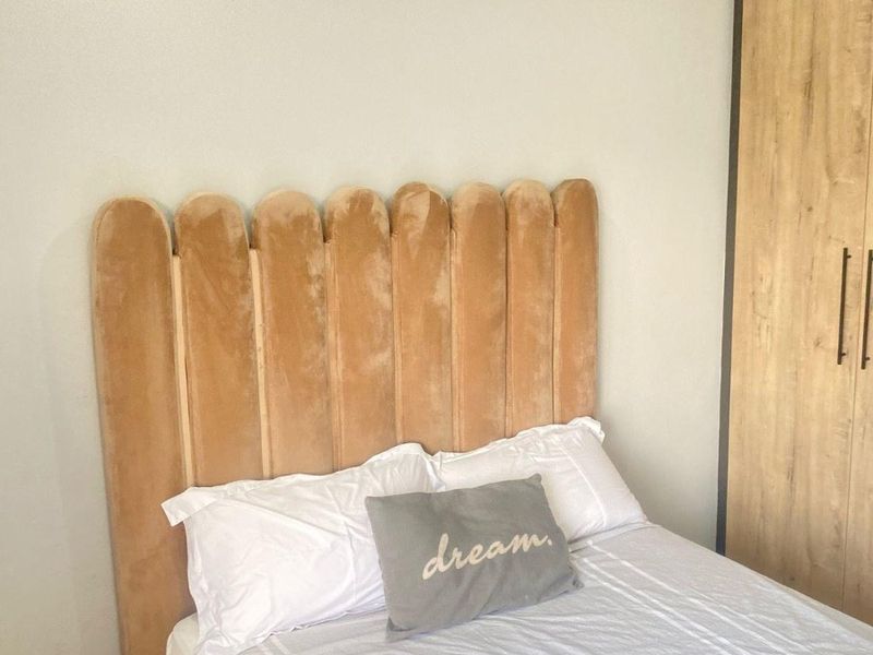 A well-maintained bedroom featuring a built-in wardrobe and decorative coving, providing a clean and functional living space.