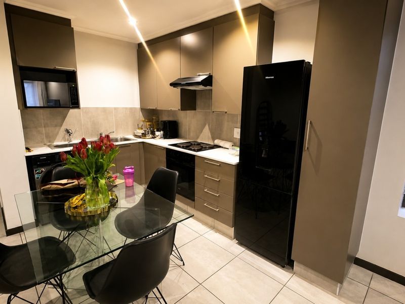 Modern kitchen featuring sleek cabinetry, integrated appliances, tiled flooring, and a functional layout with ample storage and workspace.