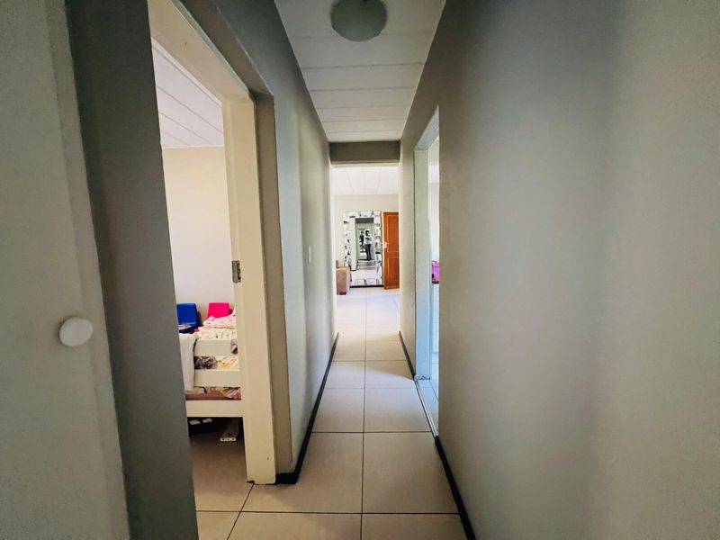 A functional hallway featuring tiled flooring and neutral wall finishes, providing access to adjacent rooms within the apartment.