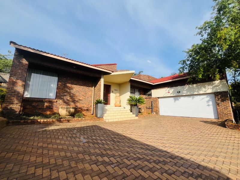 Front elevation of a brick house featuring a paved driveway, single garage, and a covered entrance porch with steps.