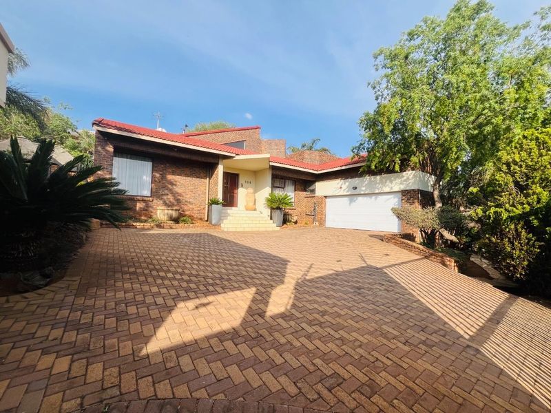 Front elevation of a brick house featuring a paved driveway, double garage, and a covered entrance porch.