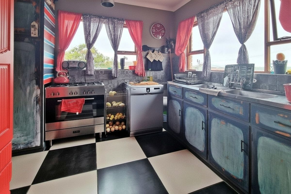 A kitchen featuring a gas stove, double sink, and tiled splashback, with a distinctive checkerboard floor and distressed-finish cabinetry.