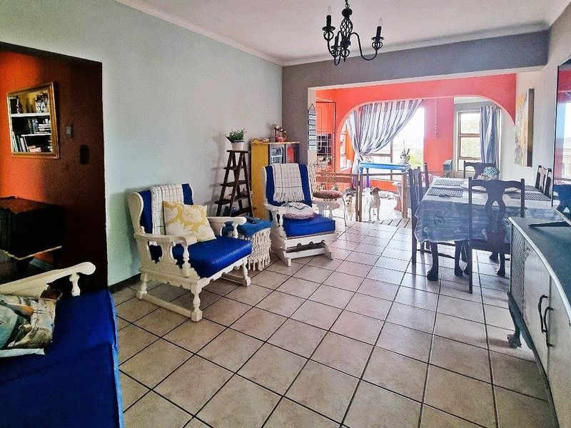 Open plan living and dining area featuring ceramic floor tiles and an arched transition to the adjacent space.