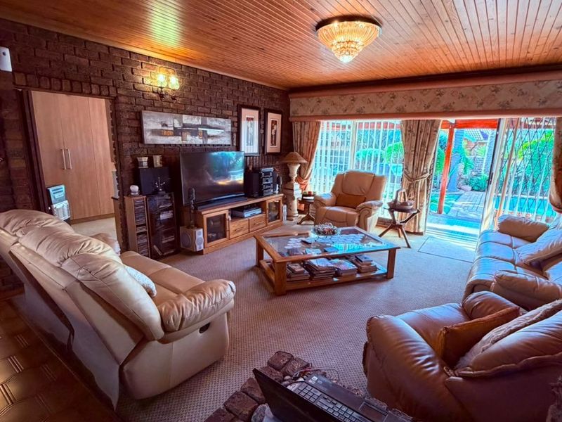 Spacious living room featuring exposed brick walls, a timber-clad ceiling with a skylight, and large sliding doors providing access to the outdoor area.