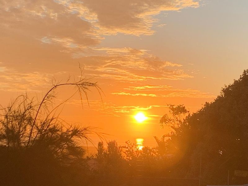A scenic sunset view over the horizon, showcasing the natural landscape and atmosphere of the property location.