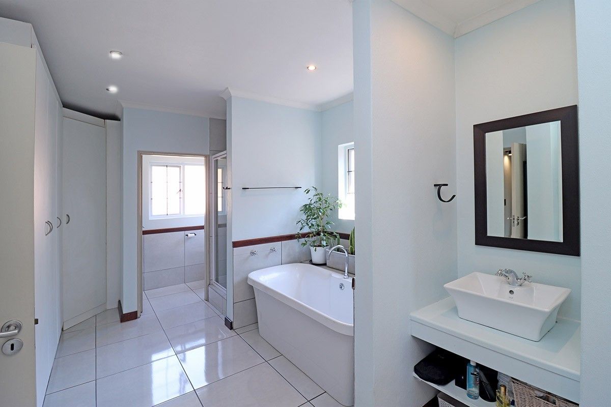 Modern bathroom featuring a freestanding bathtub, vessel sink, tiled flooring, and a separate shower enclosure with clean, neutral finishes.