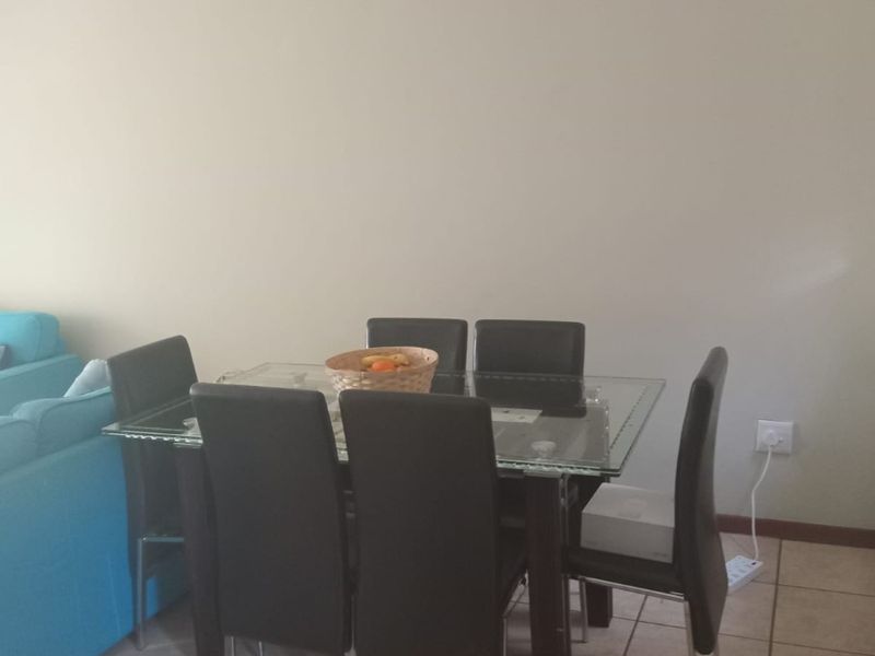 A dining area featuring neutral wall tones and tiled flooring, providing a functional space for meals.