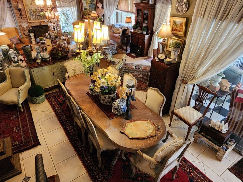 Spacious open-plan living and dining area featuring tiled floors, exposed brick accents, a fireplace, and large sliding glass doors leading to an outdoor patio.