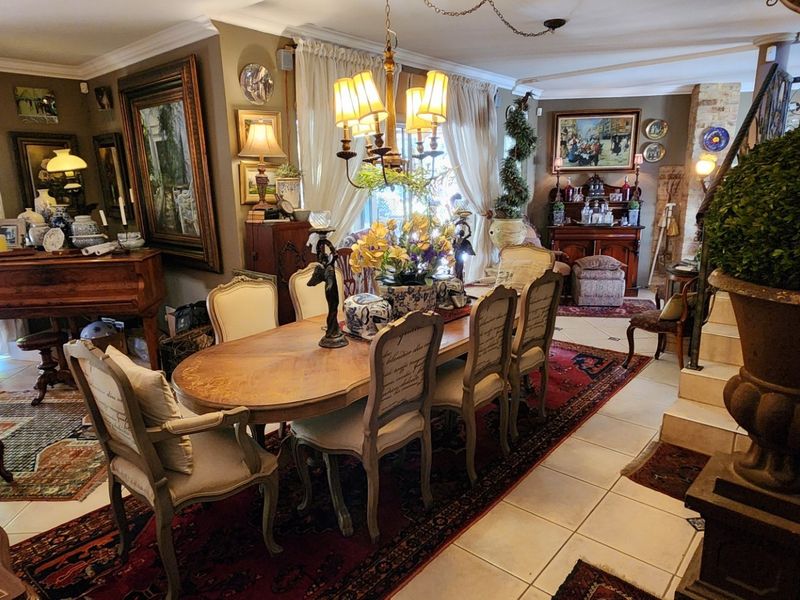 A spacious dining area featuring tiled flooring, crown molding, and direct access to the outdoor area through sliding glass doors.