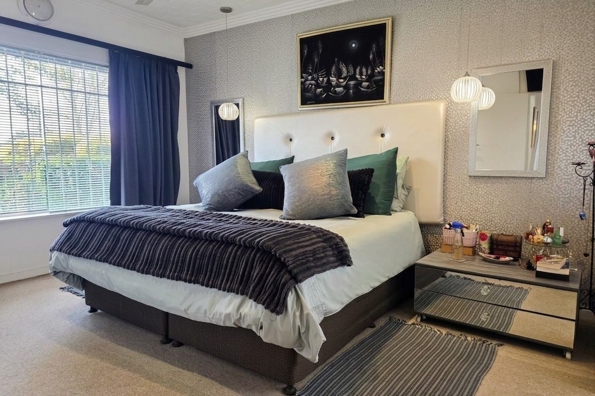A well-maintained bedroom featuring patterned wallpaper, recessed lighting, a ceiling fan, and venetian blinds.