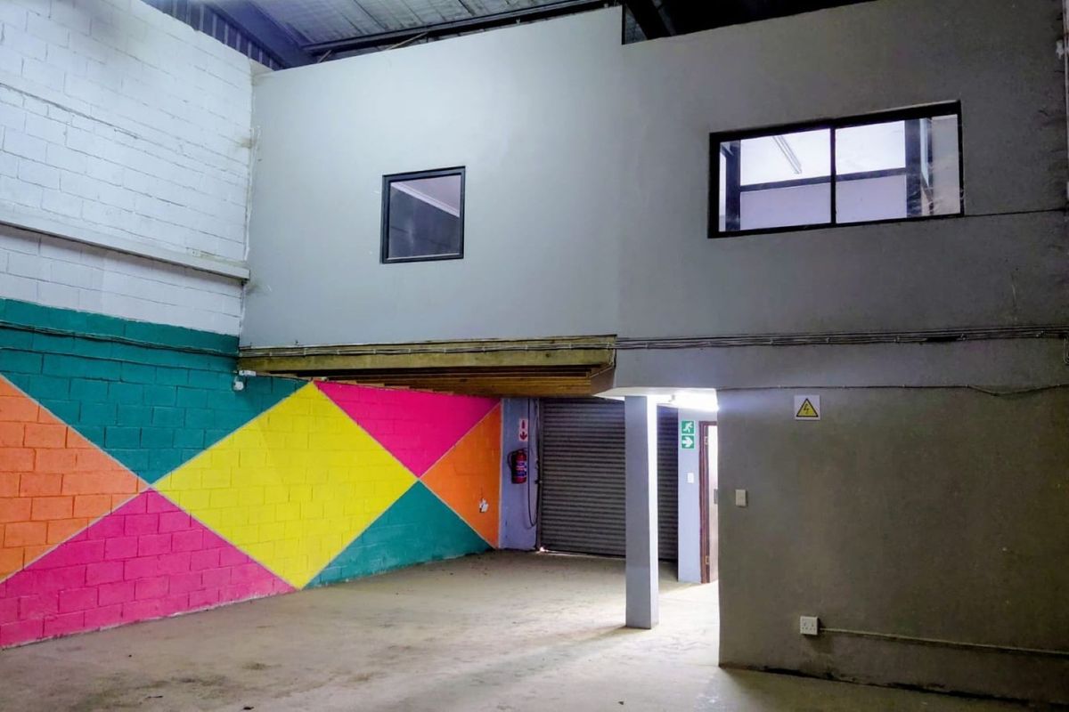 Industrial utility space featuring a mezzanine level, concrete flooring, roller shutter access, and exposed structural elements, suitable for storage or workshop use.