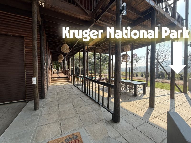 Spacious covered patio featuring timber structural columns, stone paving, and a timber balustrade, offering an ideal outdoor entertainment area overlooking the garden.