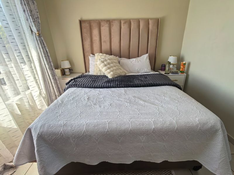 A well-maintained bedroom featuring a neutral color palette, soft natural lighting from the window, and a clean, comfortable layout.
