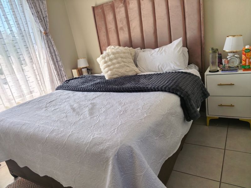 A well-maintained bedroom featuring tiled flooring and neutral wall finishes, providing a comfortable and functional sleeping space.