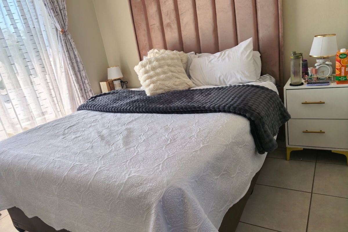 A well-maintained bedroom featuring tiled flooring and neutral wall finishes, providing a comfortable and functional sleeping space.