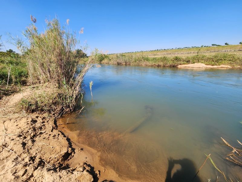A scenic view of the river flowing through the farm property, featuring natural banks and surrounding landscape.