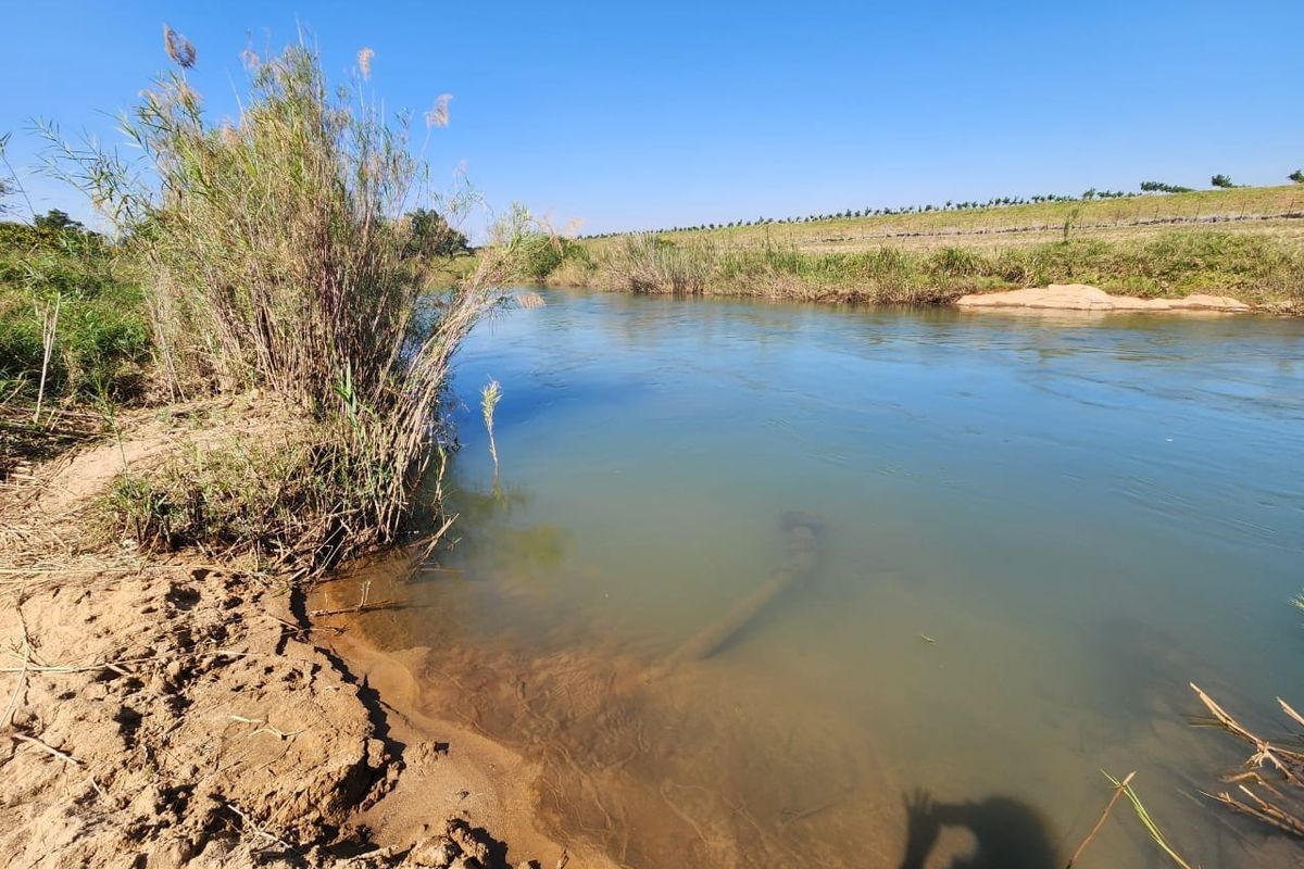 A scenic view of the river flowing through the farm property, featuring natural banks and surrounding landscape.