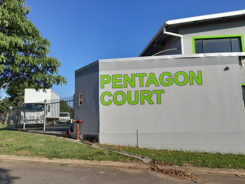 Front exterior view of the industrial property known as Pentagon Court, featuring a secure perimeter fence and prominent signage.