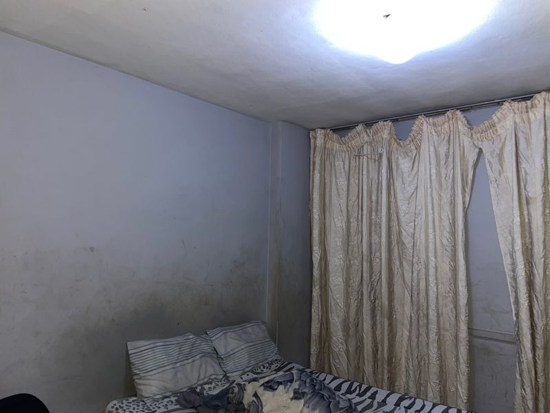 A bedroom featuring wall surfaces with visible staining and discoloration, requiring maintenance and cosmetic updates to improve the overall condition.