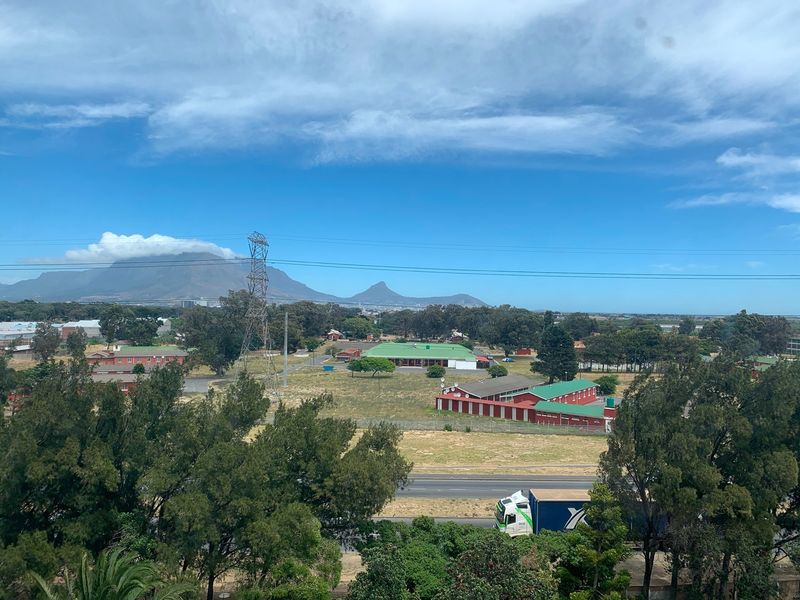 Elevated panoramic view overlooking the surrounding landscape, featuring distant mountains, open grounds, and nearby infrastructure.