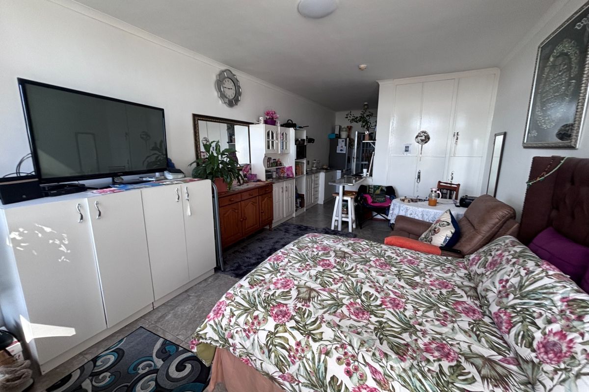 Open-plan living and sleeping area featuring tiled flooring, built-in cabinetry, and ample storage space within a retirement village unit.