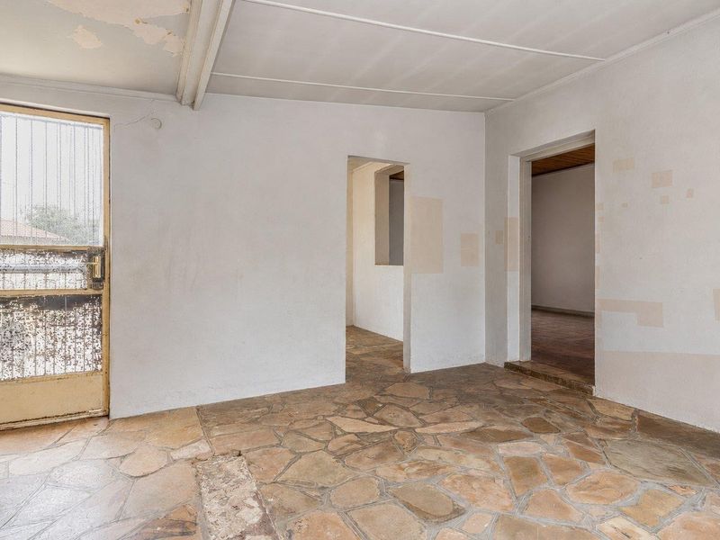 An empty entrance area featuring stone flooring, requiring cosmetic updates to the walls and ceiling to restore its condition.
