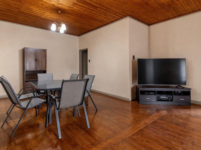 A living area featuring warm timber ceilings and original hardwood flooring, offering a classic foundation for modern interior updates.