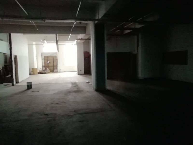 An expansive, unfinished commercial utility space featuring exposed concrete ceilings, structural columns, and raw concrete flooring, suitable for various industrial or commercial fit-out purposes.