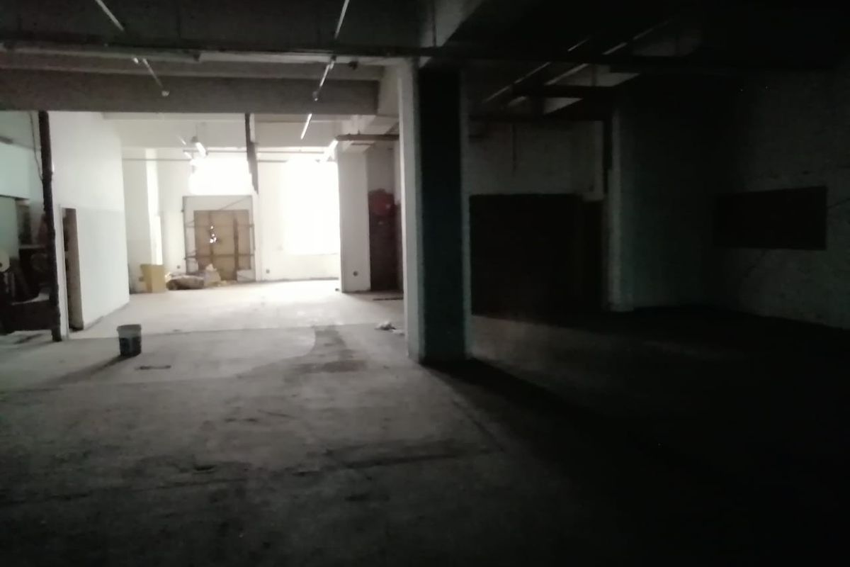 An expansive, unfinished commercial utility space featuring exposed concrete ceilings, structural columns, and raw concrete flooring, suitable for various industrial or commercial fit-out purposes.
