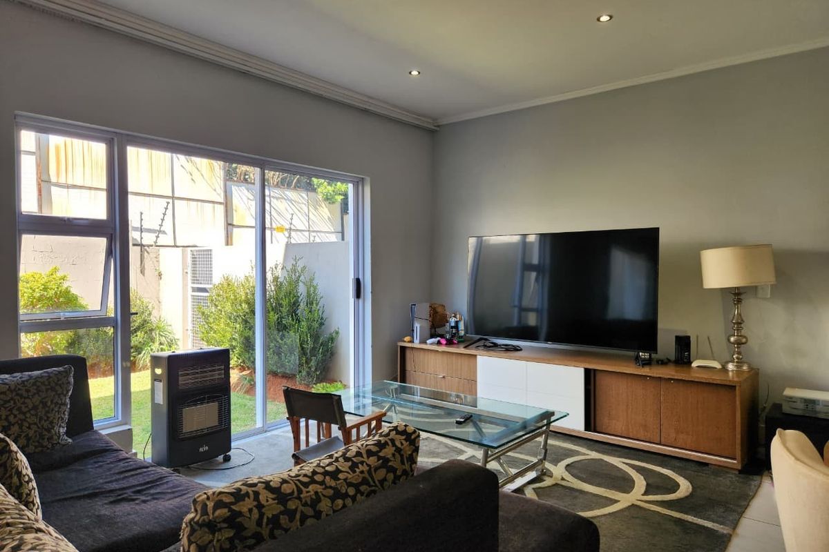 A bright living room featuring large sliding glass doors that provide natural light and direct access to the outdoor garden area.