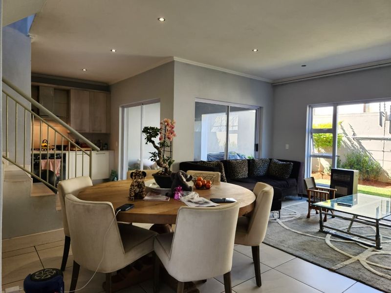 Spacious open-plan living and dining area featuring tiled floors, recessed lighting, and direct access to the outdoor patio through sliding glass doors.