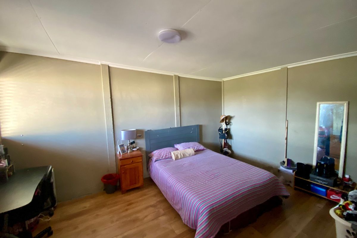 A standard bedroom featuring laminate flooring and neutral wall finishes, providing a functional space ready for personalization.