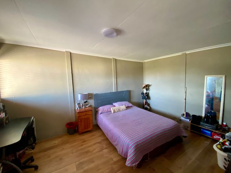 A standard bedroom featuring laminate flooring and neutral wall finishes, providing a functional space ready for personalization.