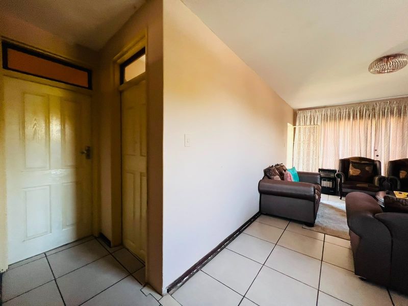 Living area featuring tiled flooring and internal doors with transom windows, requiring minor cosmetic updates to skirting and wall finishes.