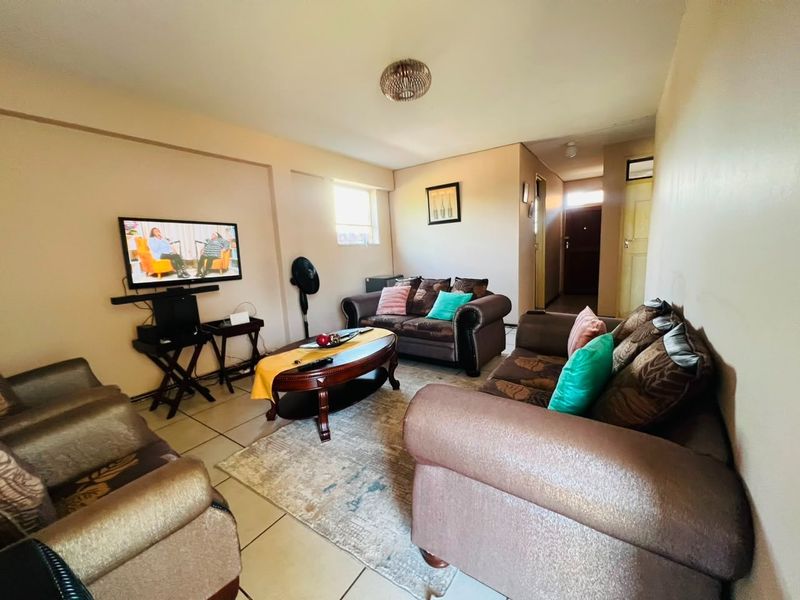A living room area featuring tiled flooring and neutral wall finishes, providing a functional space for relaxation.
